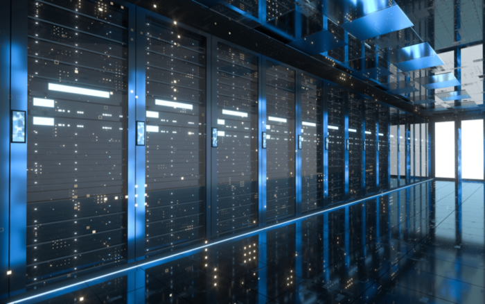 A wall of modern server racks ina glass building with a polished floor highlighting the lights